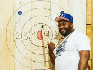 man throwing axe at an indoor target