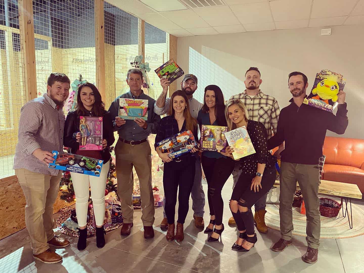 Image of individuals posing in a pic while holding prizes from their corporate event held at Throw Lumber Jills' axe-throwing lounge - www.jills.cloudsend.us