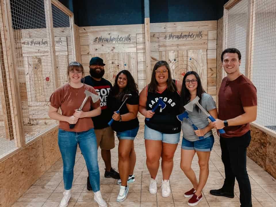 Image of 6 individuals holding axes while posing for a picture taken at Throw Lumber Jills' axe-throwing lanes - www.jills.cloudsend.us